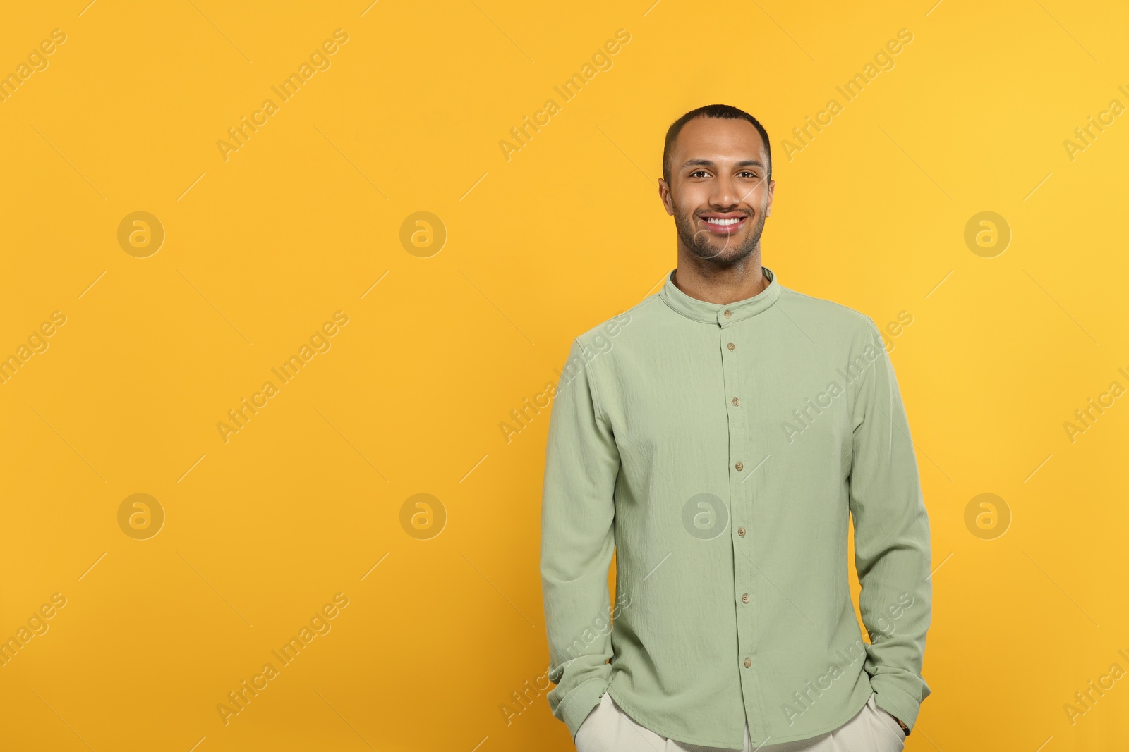 Photo of Portrait of handsome young man on orange background, space for text