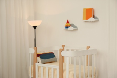 Cute baby room interior with stylish crib and lamp