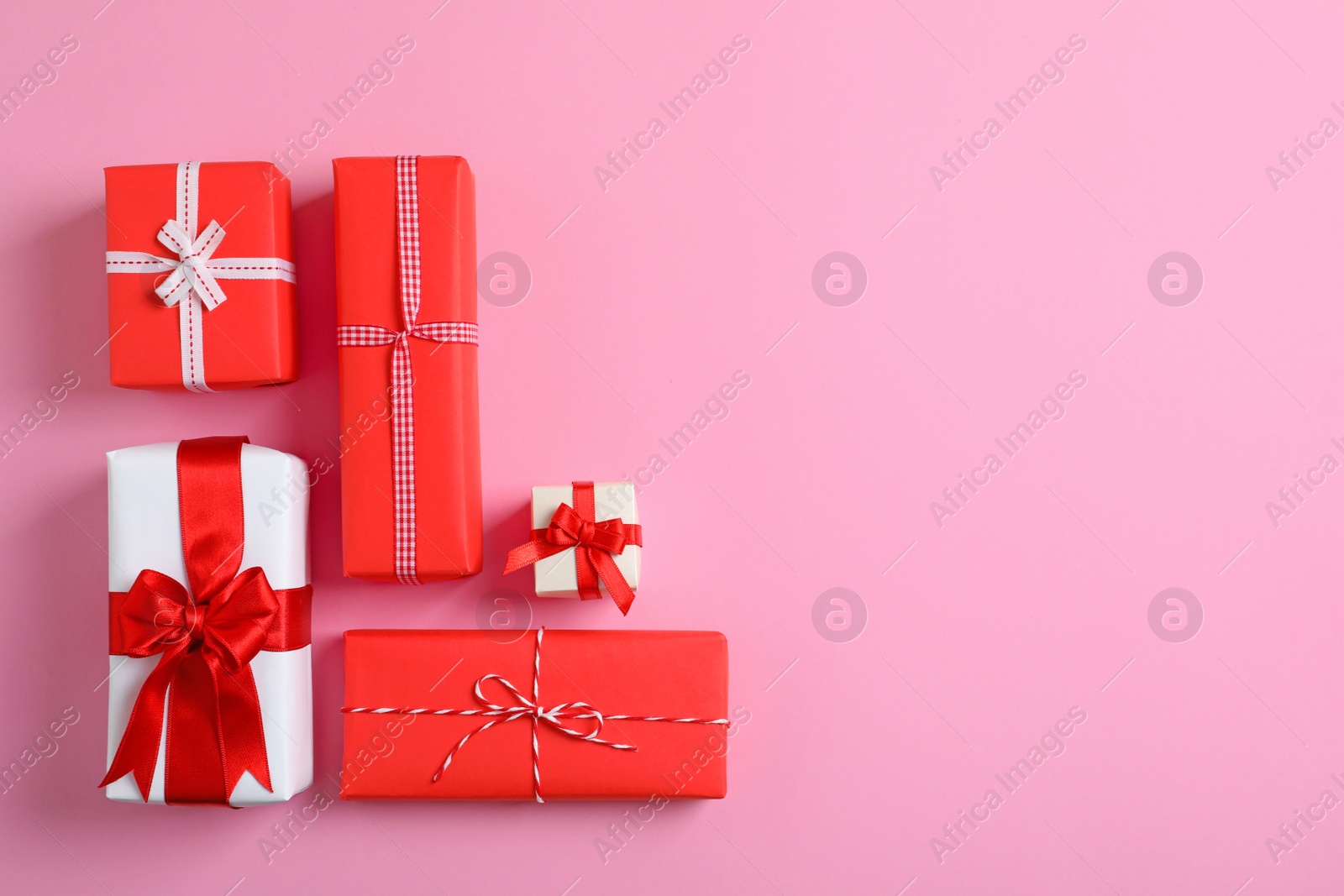 Photo of Beautifully wrapped gift boxes on color background, top view