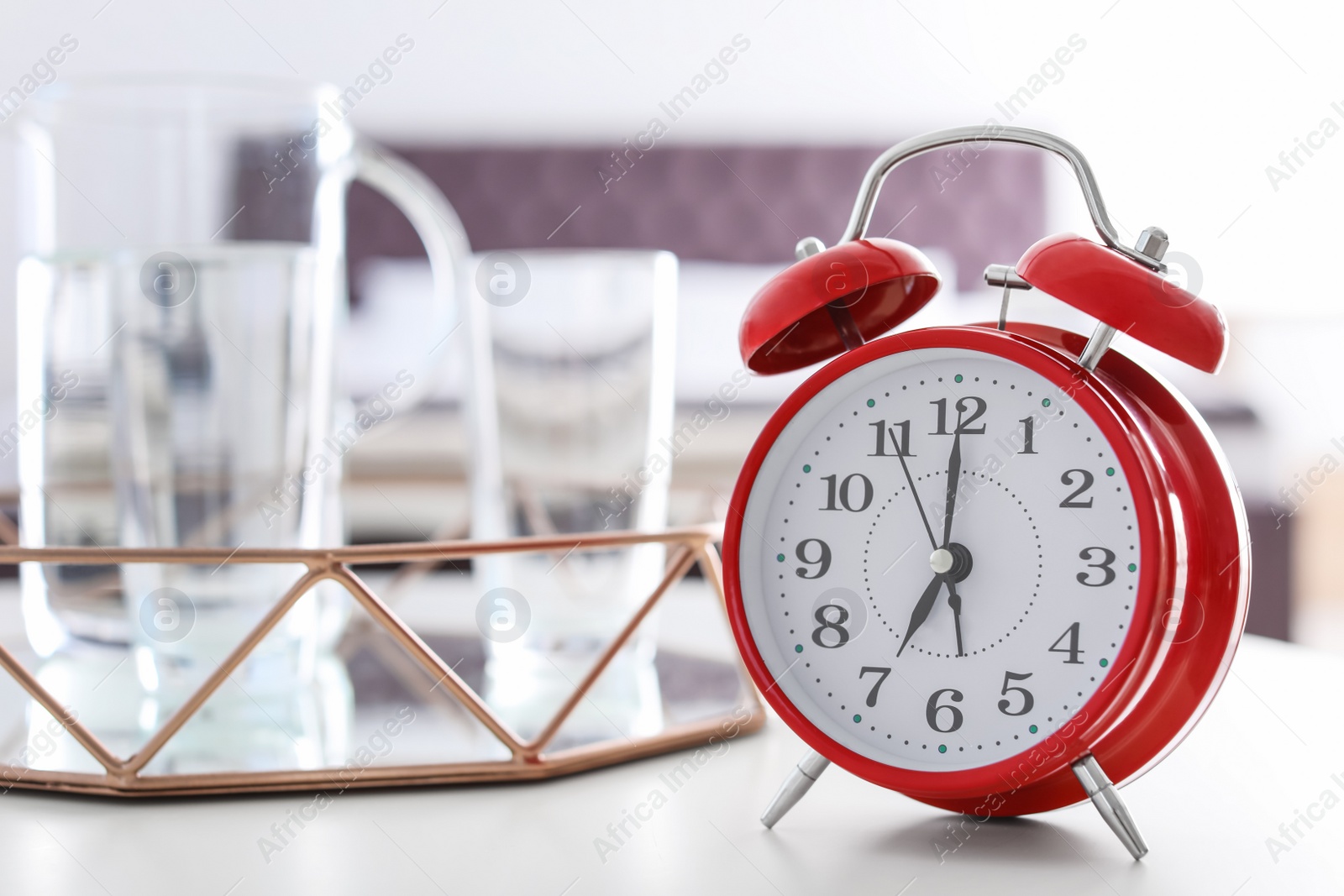 Photo of Alarm clock on table in bedroom. Time of day