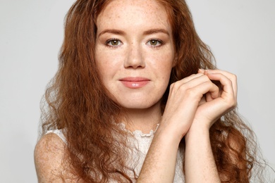 Portrait of young woman with beautiful face on grey background, closeup