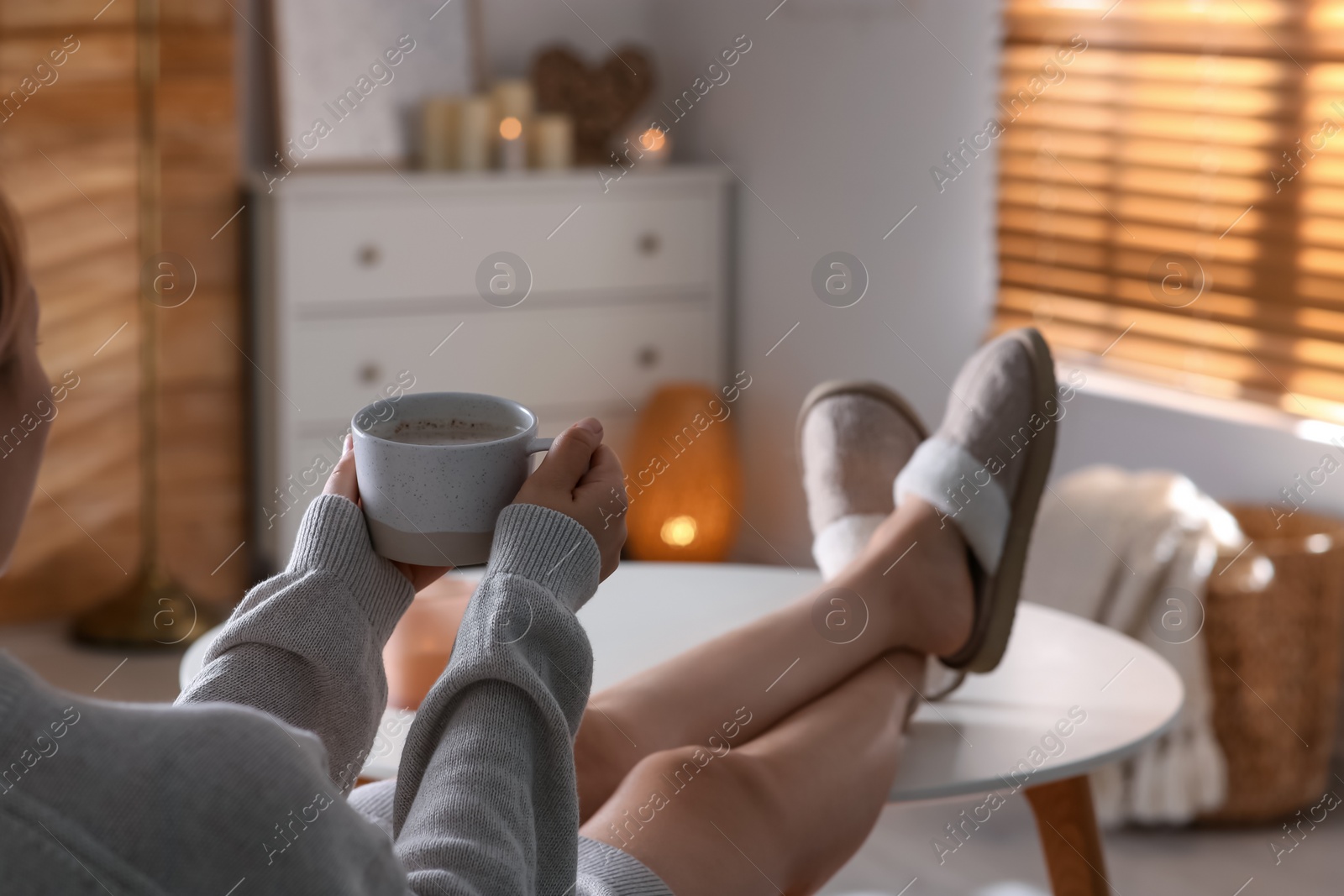 Photo of Woman with cup of aromatic coffee relaxing at home, closeup