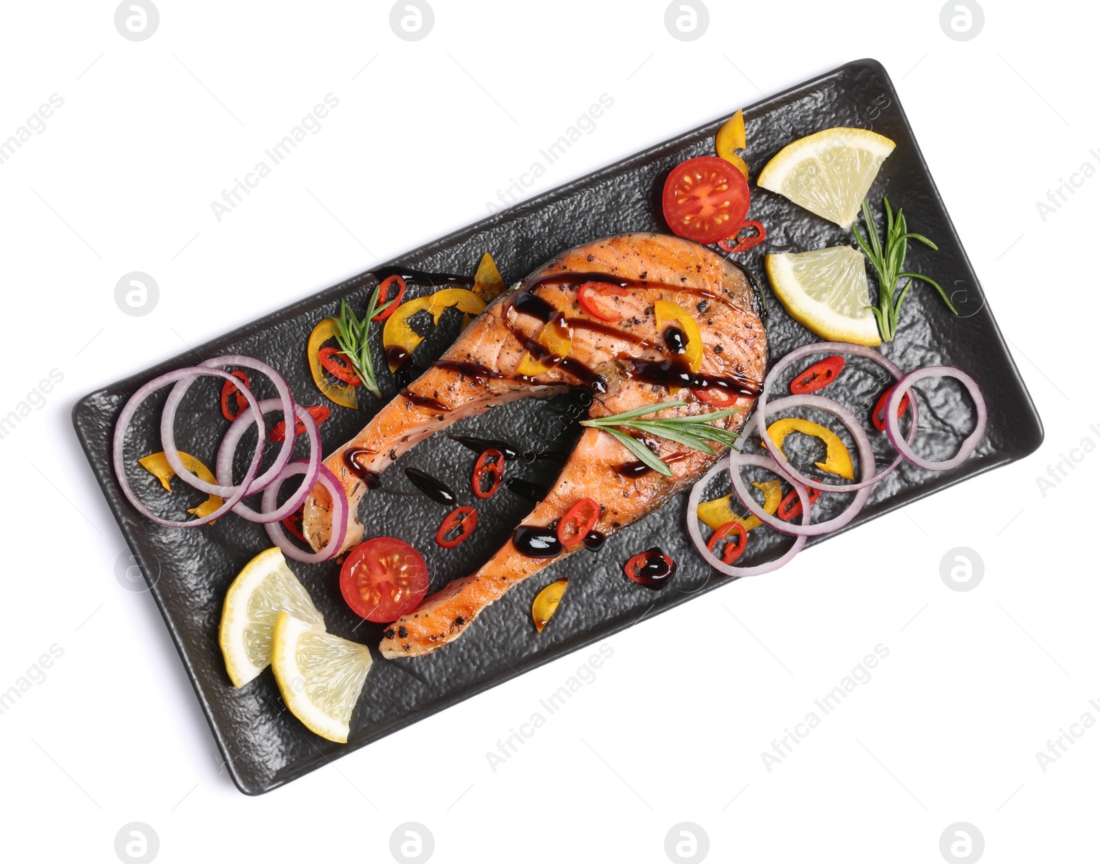 Photo of Slate plate with tasty salmon steak, lemon and vegetables isolated on white, top view