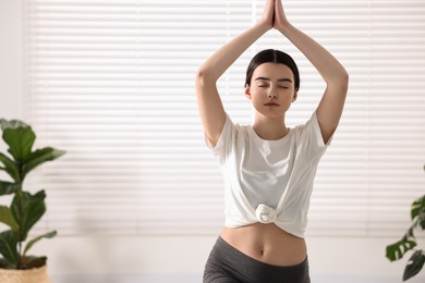 Photo of Girl practicing crescent asana in yoga studio. High lunge pose