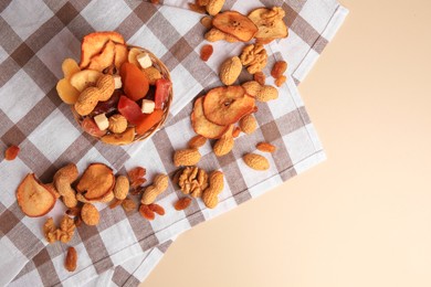 Photo of Mixed dried fruits and nuts on beige background, top view. Space for text