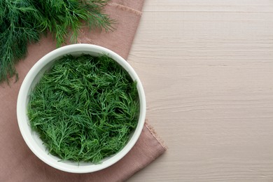 Bowl of fresh dill on wooden table, top view. Space for text