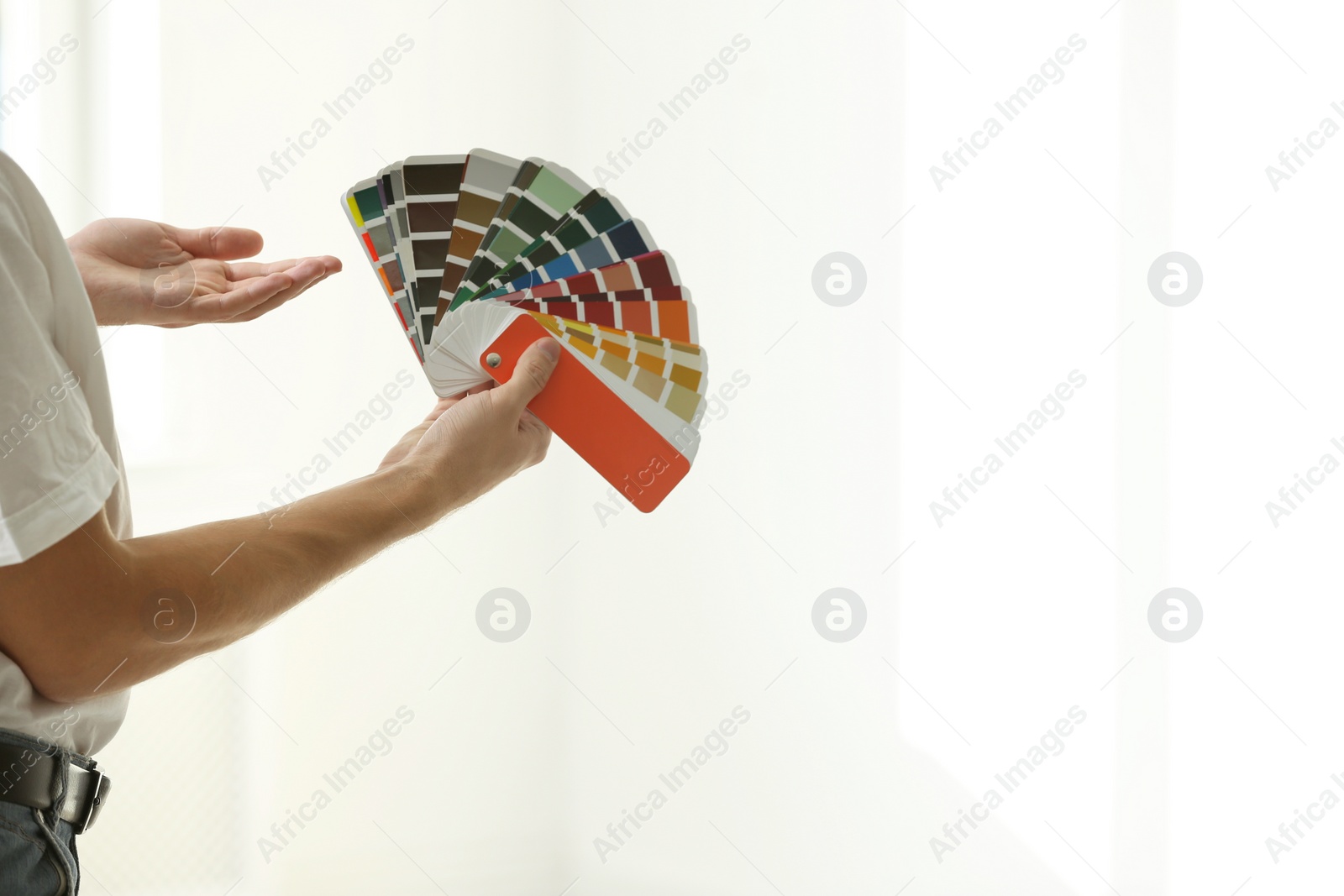 Photo of Professional interior designer with color palette on light background, closeup. Space for text
