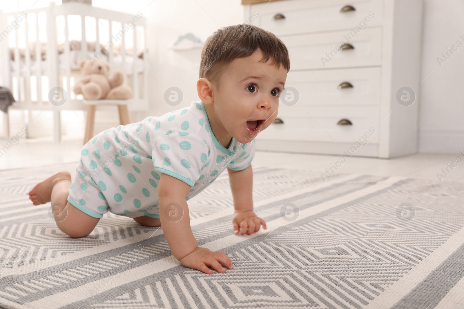 Photo of Cute baby crawling on floor at home