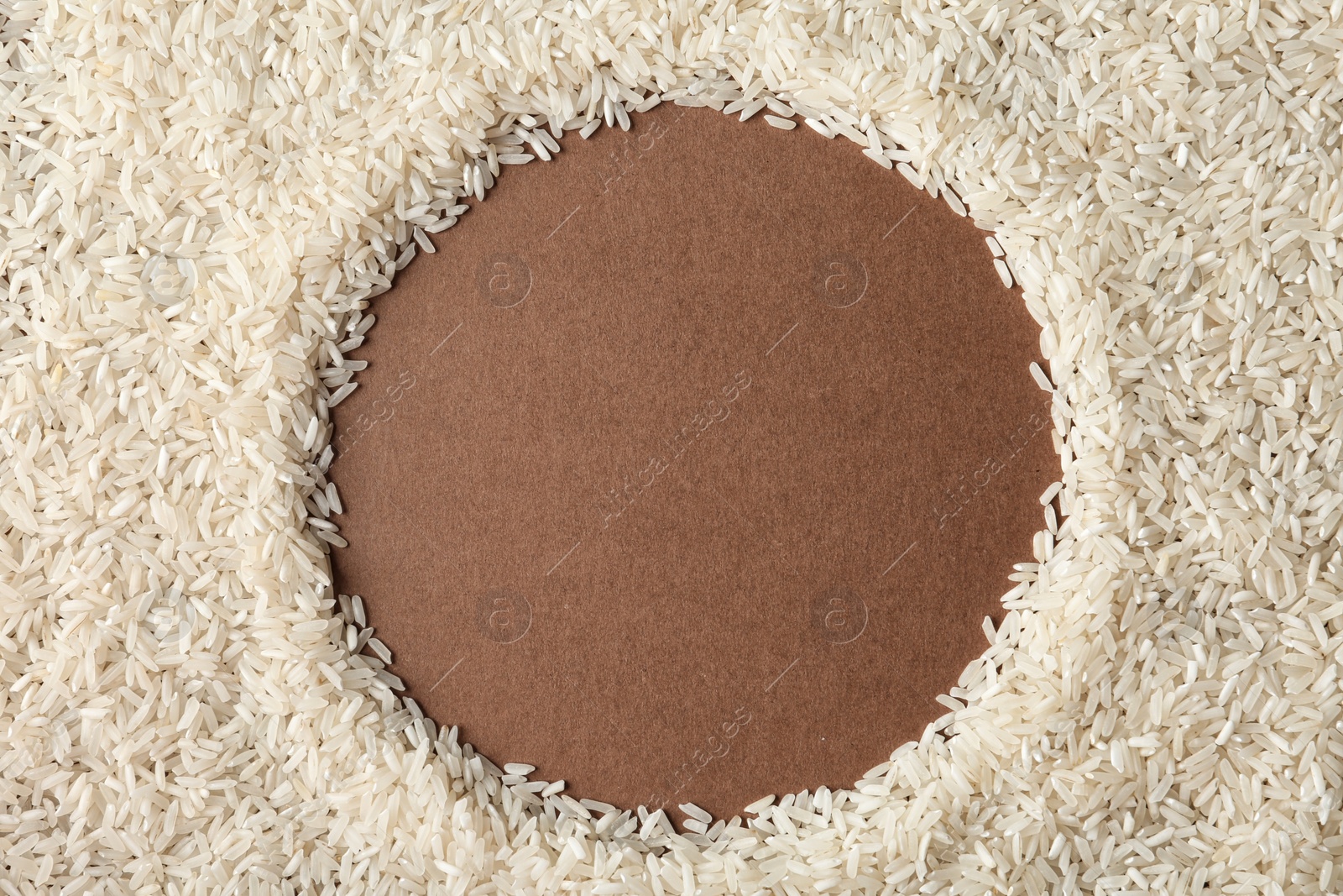 Photo of Round frame made with long grain rice on color background, top view. Space for text