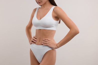 Young woman in stylish bikini on white background, closeup