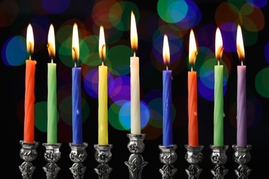 Photo of Hanukkah celebration. Menorah with burning candles against blurred lights, closeup
