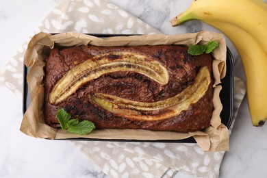 Photo of Delicious banana bread and fresh fruits on white marble table, top view