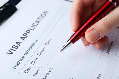 Woman filling visa application form for immigration, closeup