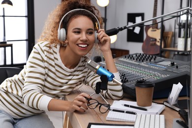 African American woman working as radio host in modern studio
