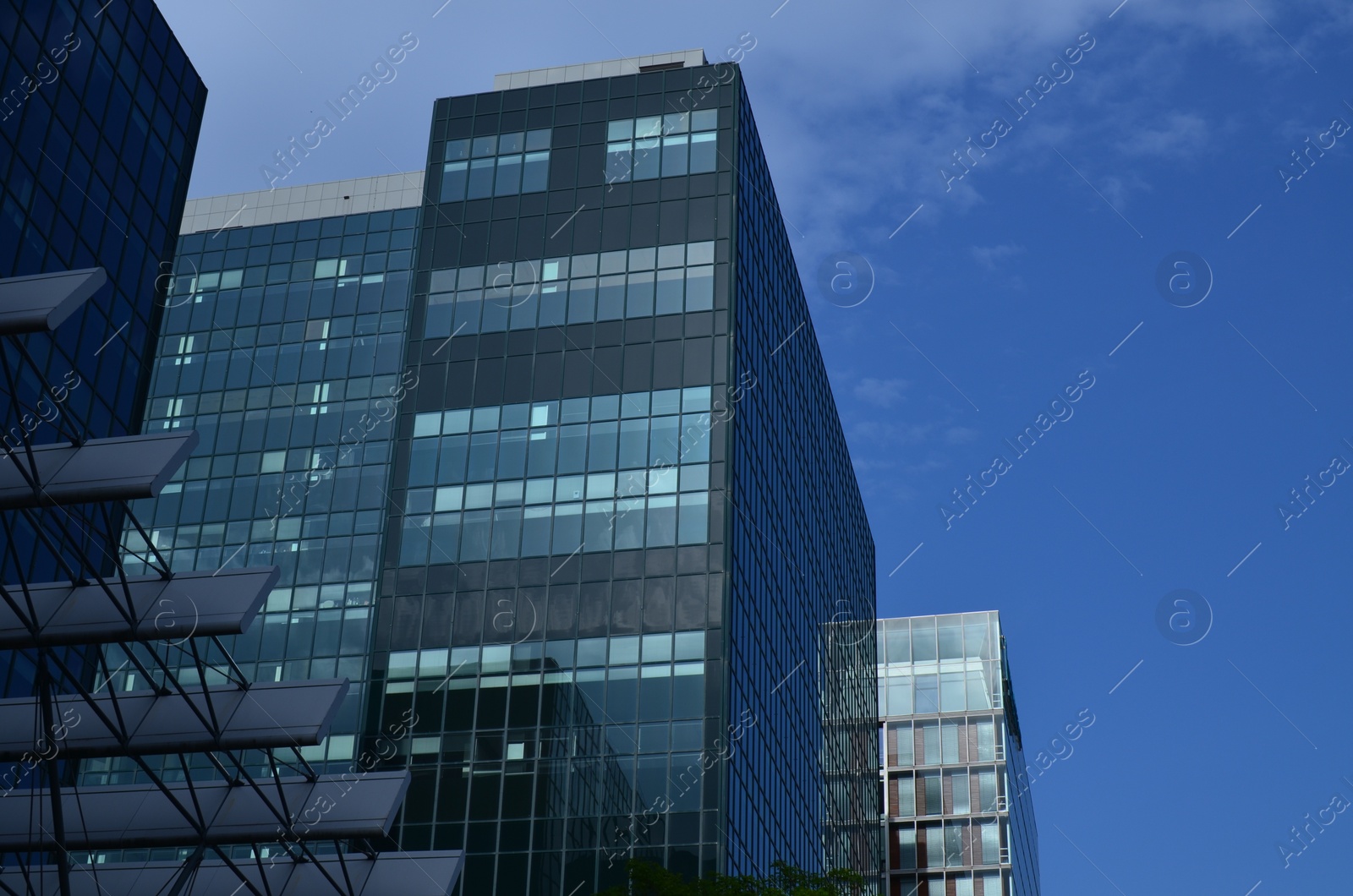 Photo of Exterior of beautiful modern skyscraper against blue sky, low angle view