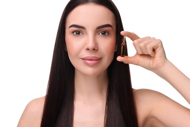 Beautiful young woman holding skincare ampoule on white background