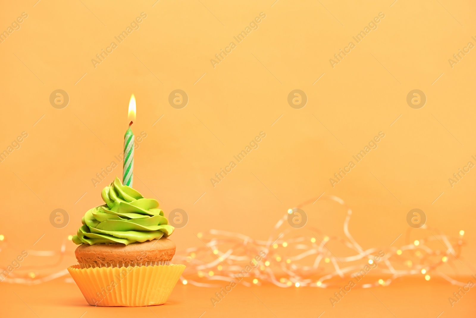 Photo of Birthday cupcake with candle on color background