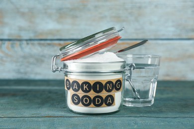 Photo of Jar with baking soda and glass of water on light blue wooden table