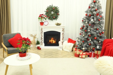 Beautiful living room interior with burning fireplace and Christmas tree