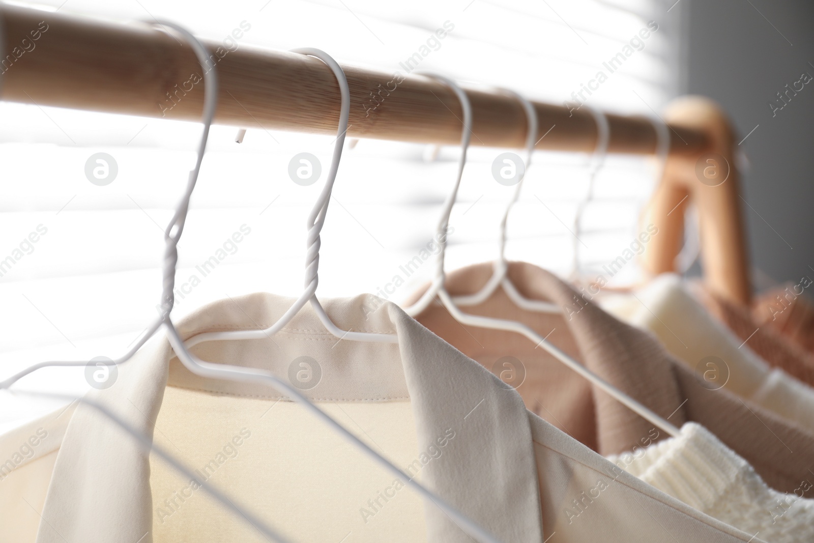 Photo of Rack with stylish women's clothes indoors, closeup. Modern interior design
