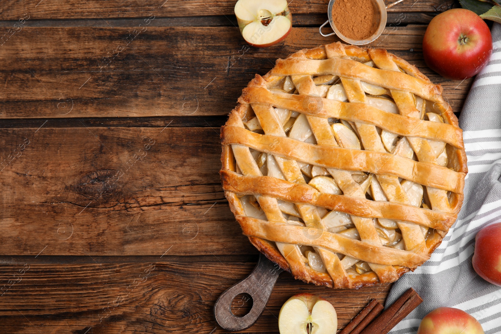 Photo of Delicious traditional apple pie on wooden table, flat lay. Space for text