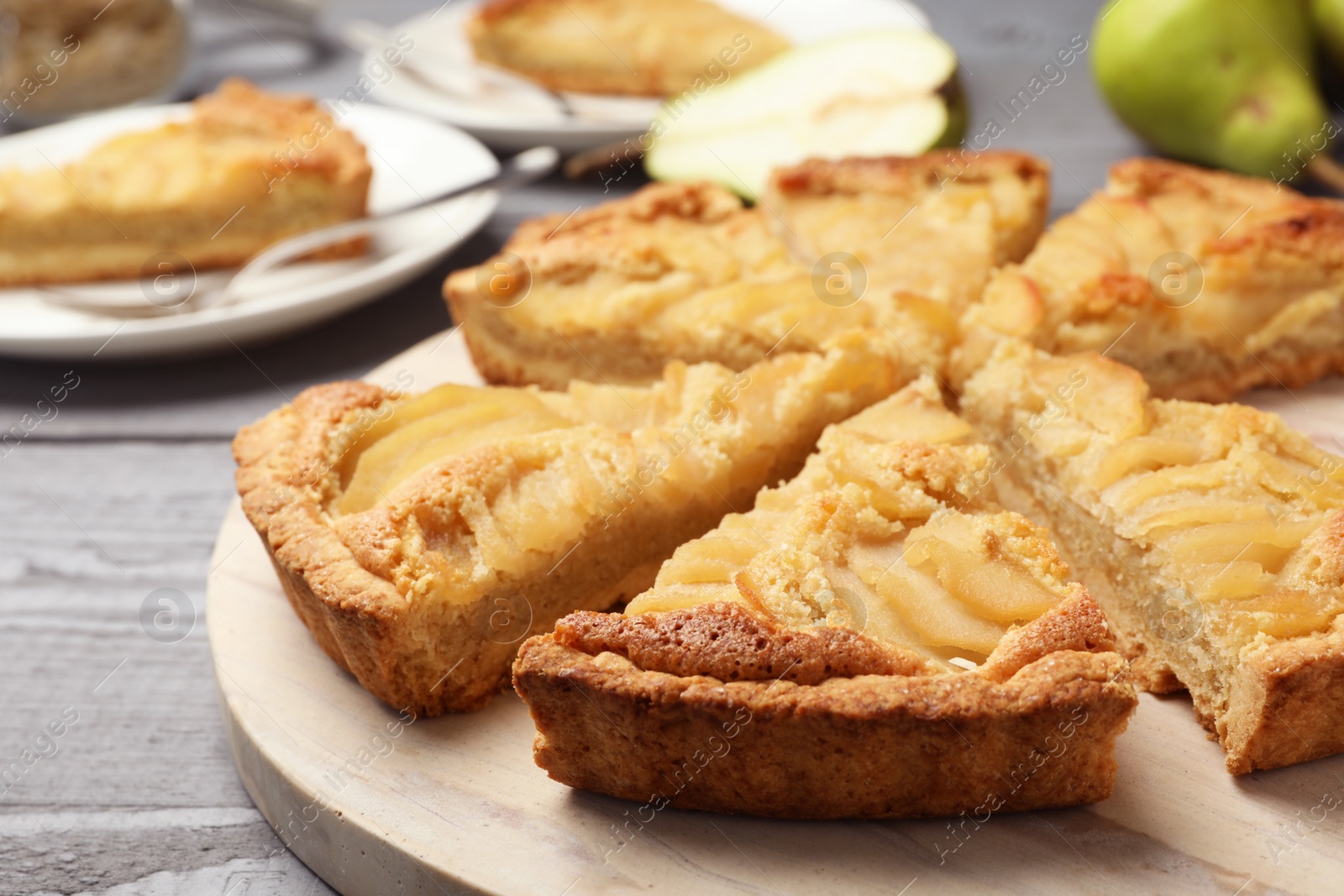 Photo of Cut delicious sweet pear tart on wooden table, closeup