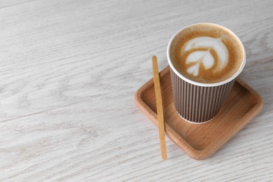 Photo of Coffee to go. Paper cup with tasty drink on white wooden table, space for text