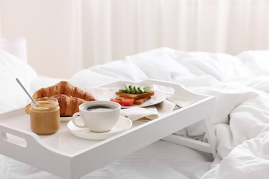 Photo of Good morning. Tray with tasty breakfast on bed at home