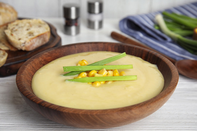 Delicious corn cream soup served on white wooden table