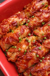 Photo of Delicious stuffed cabbage rolls cooked with tomato sauce in baking dish, top view