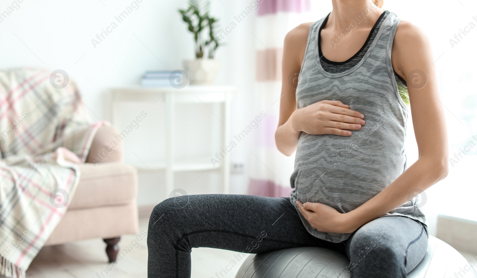 Photo of Young pregnant woman doing exercises at home