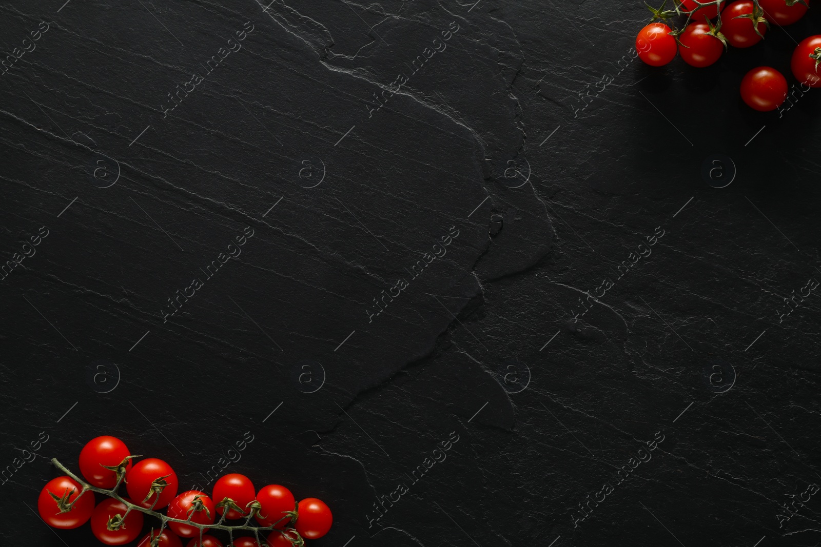 Photo of Food photography. Fresh cherry tomatoes on black table, flat lay with space for text