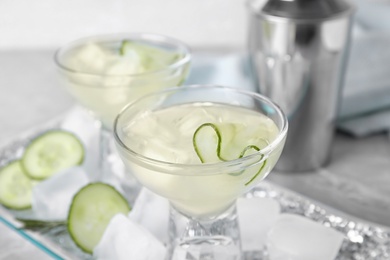 Glass of tasty cucumber martini on table, closeup