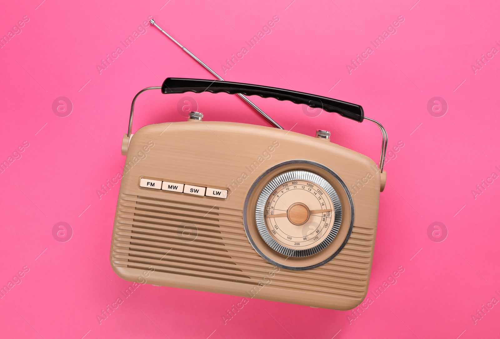 Photo of Retro radio receiver on pink background, top view