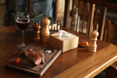 Tasty roasted meat served on wooden table in restaurant. Cooking food