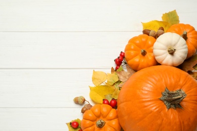 Photo of Flat lay composition with pumpkins and autumn leaves on white wooden table. Space for text