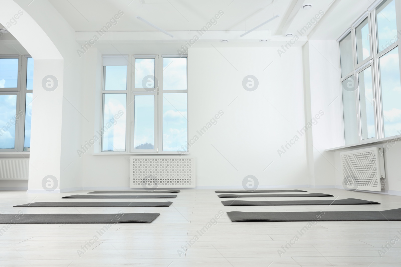 Photo of Spacious yoga studio with exercise mats, low angle view