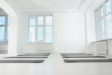 Photo of Spacious yoga studio with exercise mats, low angle view