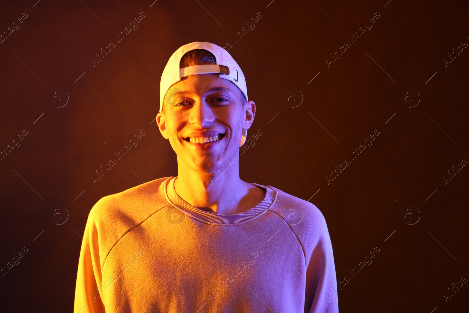 Photo of Young man on brown background in neon light