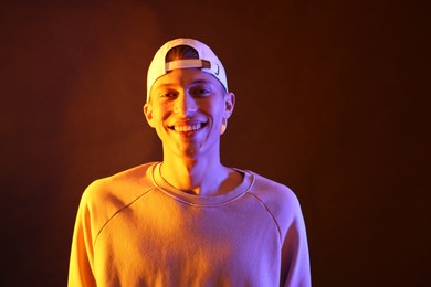 Young man on brown background in neon light