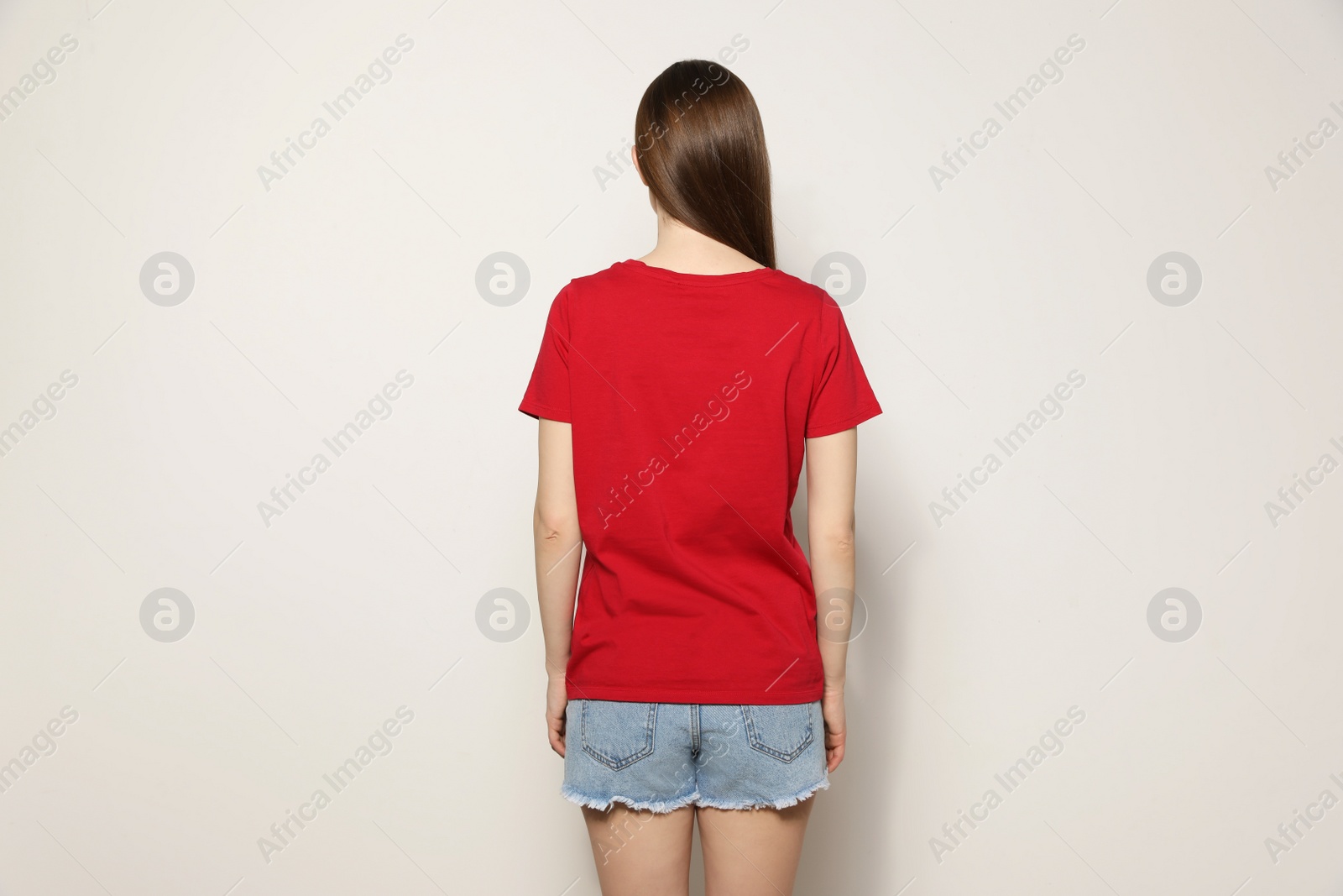 Photo of Young woman in t-shirt on light background. Mock up for design