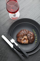 Photo of Tasty grilled beef meat served on black table, flat lay