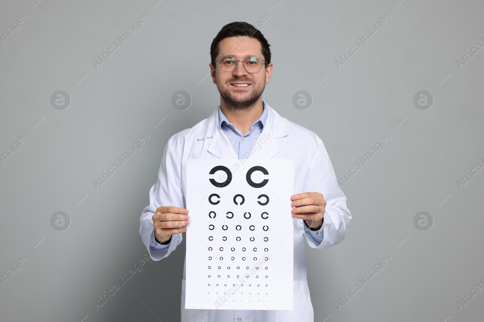 Photo of Ophthalmologist with vision test chart on gray background