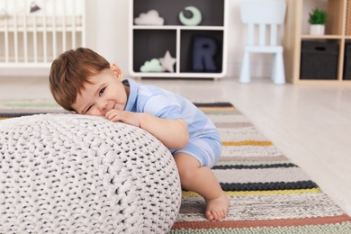 Cute baby with pouf at home. Learning to walk