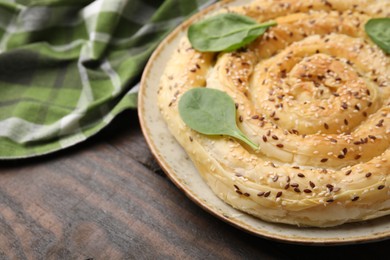 Photo of Delicious puff pastry with spinach on wooden table, closeup