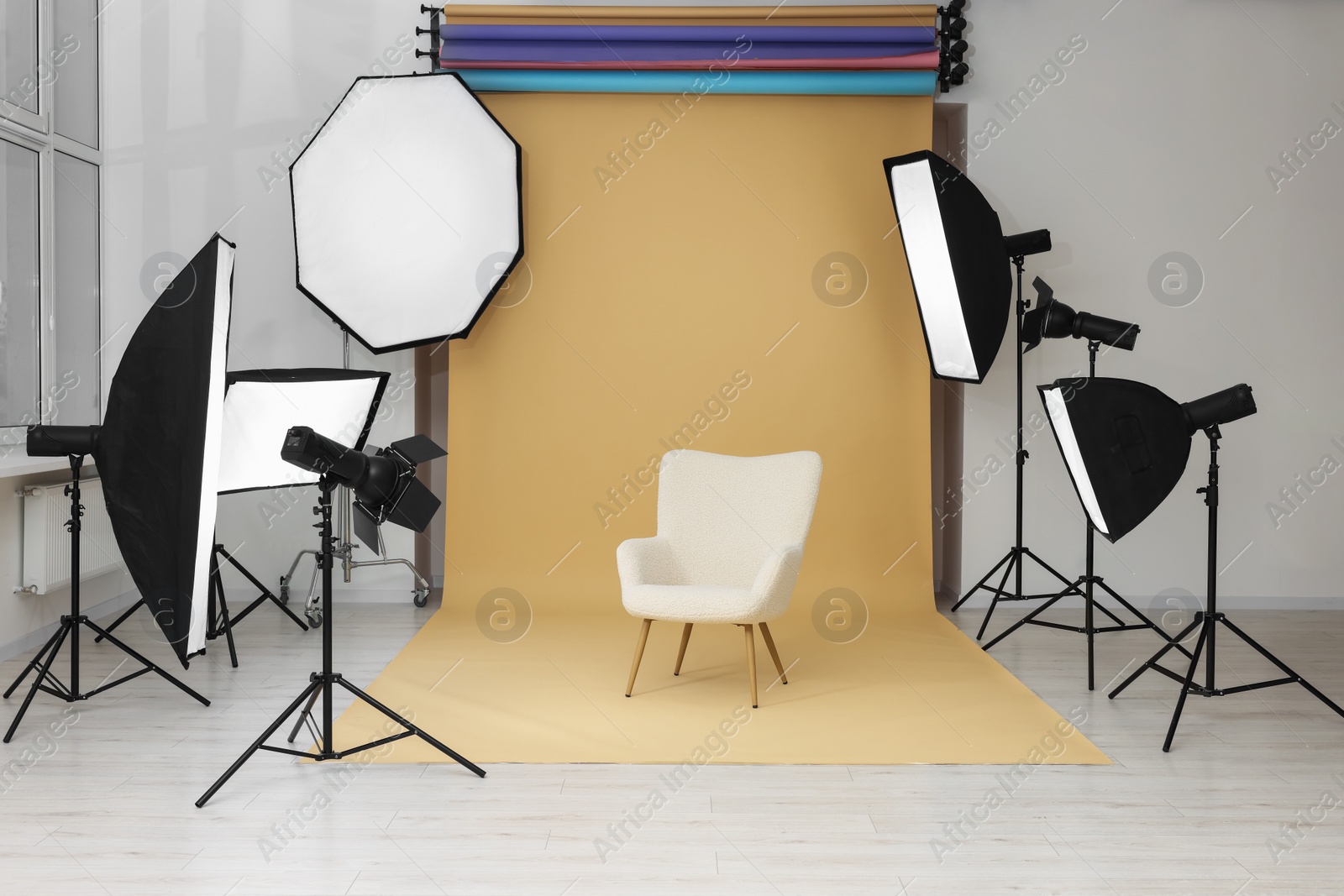 Photo of Interior of modern photo studio with armchair and professional lighting equipment