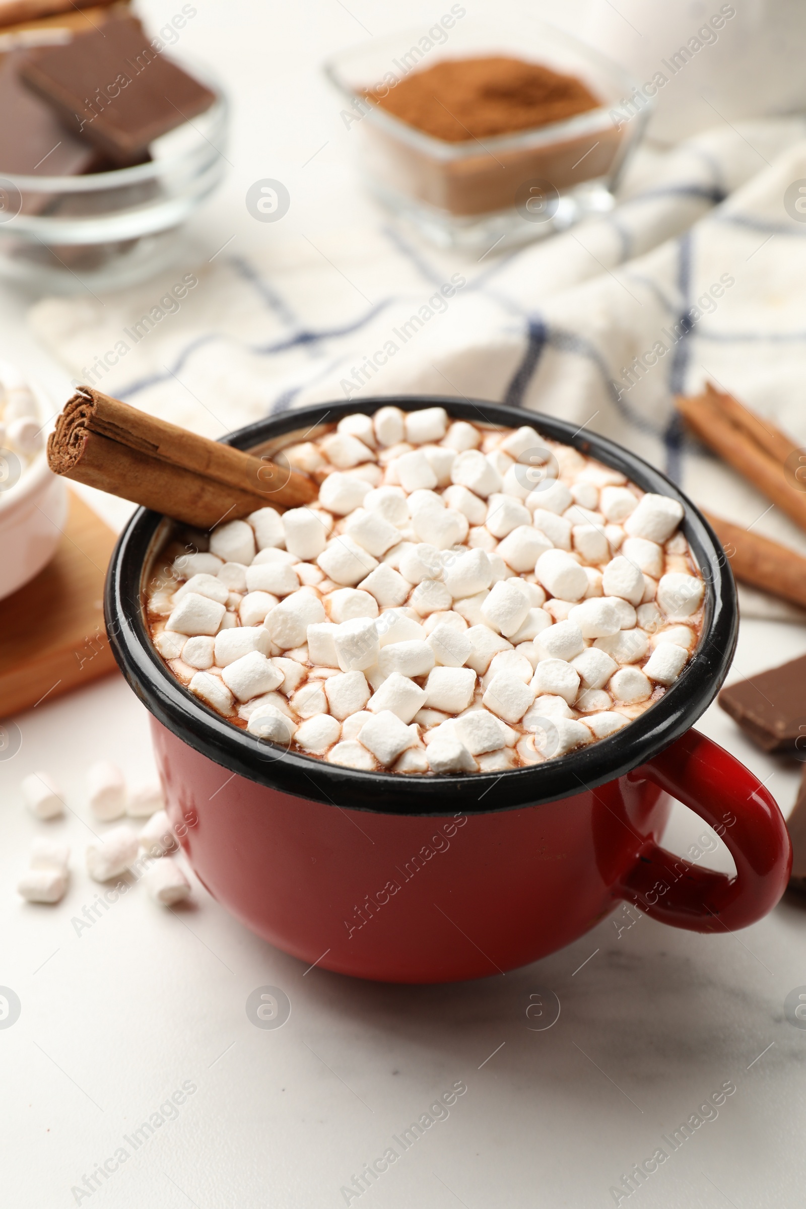 Photo of Tasty hot chocolate with marshmallows and ingredients on white marble table, closeup