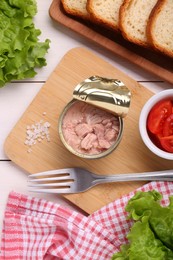 Can of conserved tuna, tomatoes and bread on white wooden table, flat lay