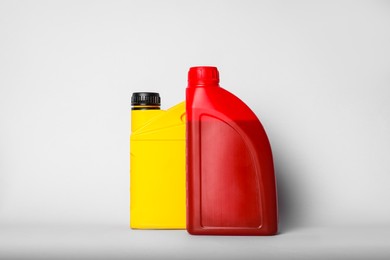 Photo of Motor oil in different canisters on light background