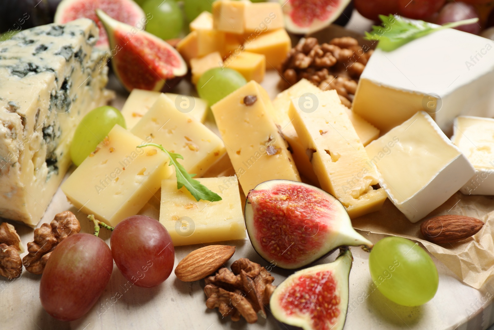 Photo of Set of different snacks with ripe figs served on board, closeup